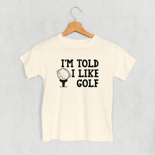 I'm Told I Like Golf Tee (Kids) POD - Apparel Ivy + Cloth Style: Toddler Tee Color: Natural Size: 2T