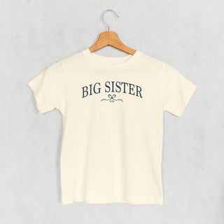 Big Sister 2026 Bow Tee (Kids) POD - Apparel Ivy + Cloth Style: Toddler Tee Color: Natural Size: 2T