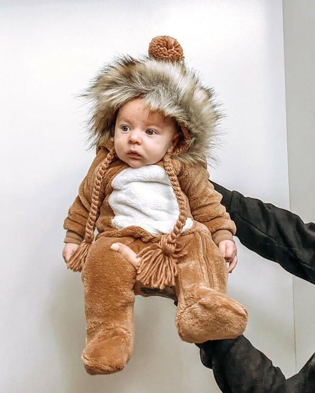 Baby wearing the Huggalugs knit fur bonnet in Pecan